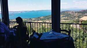 Persone sedute a tavolo con vista lago panoramica.