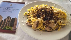 Piatto di tagliatelle ai funghi e tartufo, guida accanto.