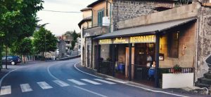 Strada curva con pizzeria e ristorante sulla destra.