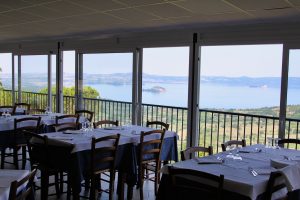 Ristorante con vista panoramica su lago e colline.
