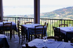 Tavoli apparecchiati su terrazza con vista panoramica.