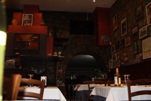 Interno di un ristorante con tavoli apparecchiati e decorazioni.