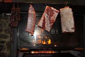 Carne appesa sopra un fuoco acceso.