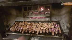 Carne e salsicce alla griglia su brace ardente.
