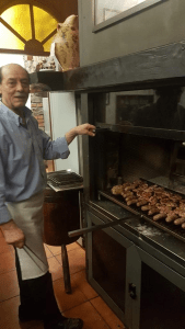 Uomo cucina carne alla griglia in un ristorante.