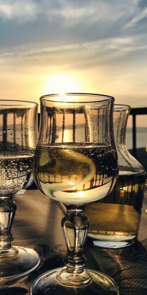 Bicchieri di vino su tavolo al tramonto.