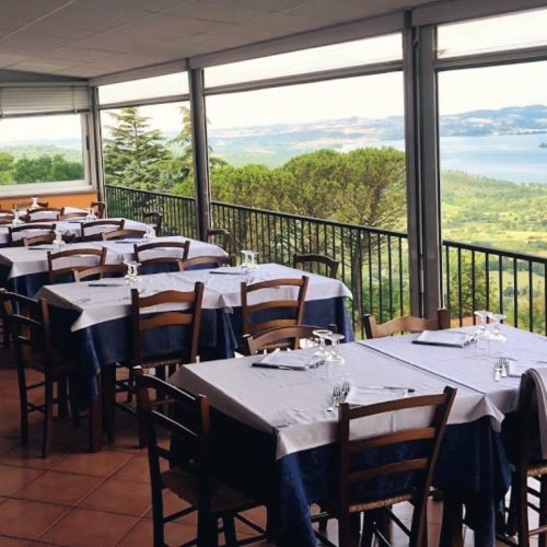 Ristorante con tavoli apparecchiati e vista panoramica.