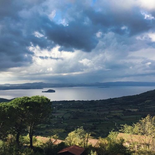 Vista panoramica di un lago con cielo nuvoloso.