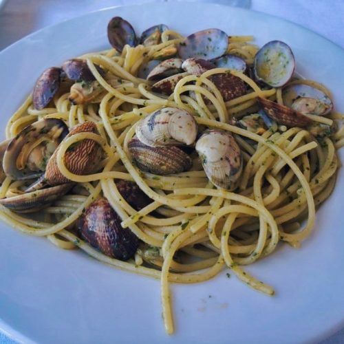Spaghetti alle vongole su piatto bianco.
